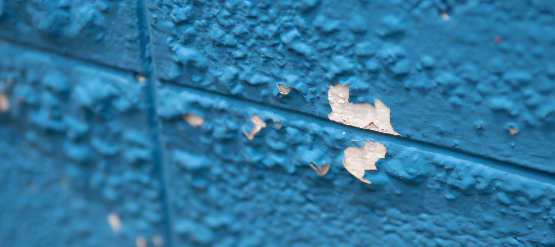paint bubbling on a concrete wall