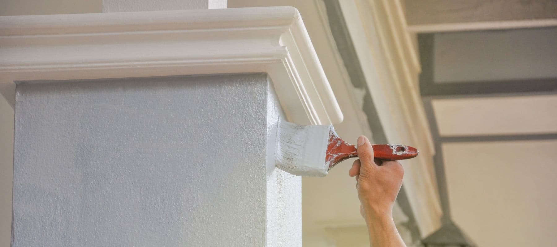 hand painting a stucco wall